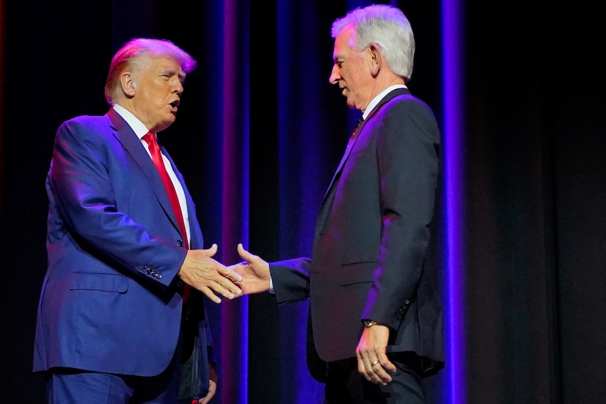 Donald Trump and Tommy Tuberville shake hands.