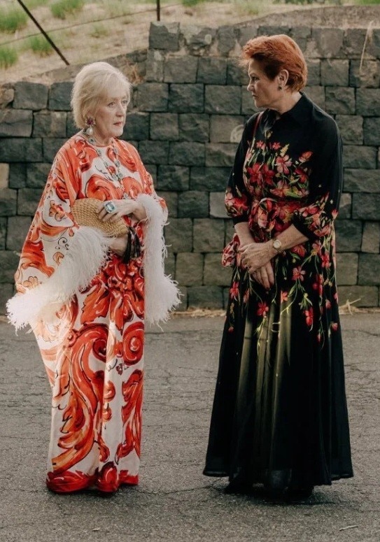 Pauline Hanson speaks to another woman. Both wear long dresses.
