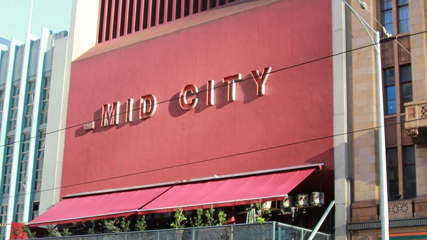 The red Hoyts Mid City building has shops on street level, a balcony on the second level and a handful of other levels.