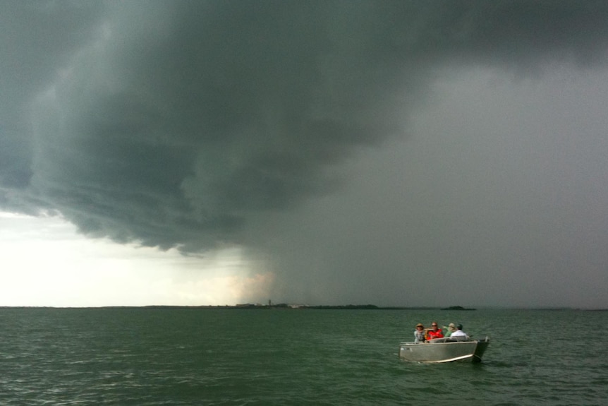 People in a 'tinny' fish in Darwin Harbour.