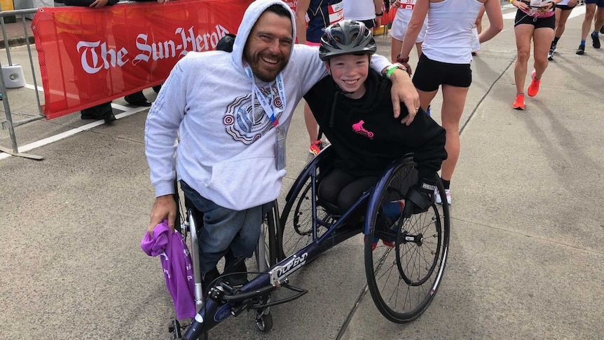 Two wheelchair athletes at the finish line of the race.