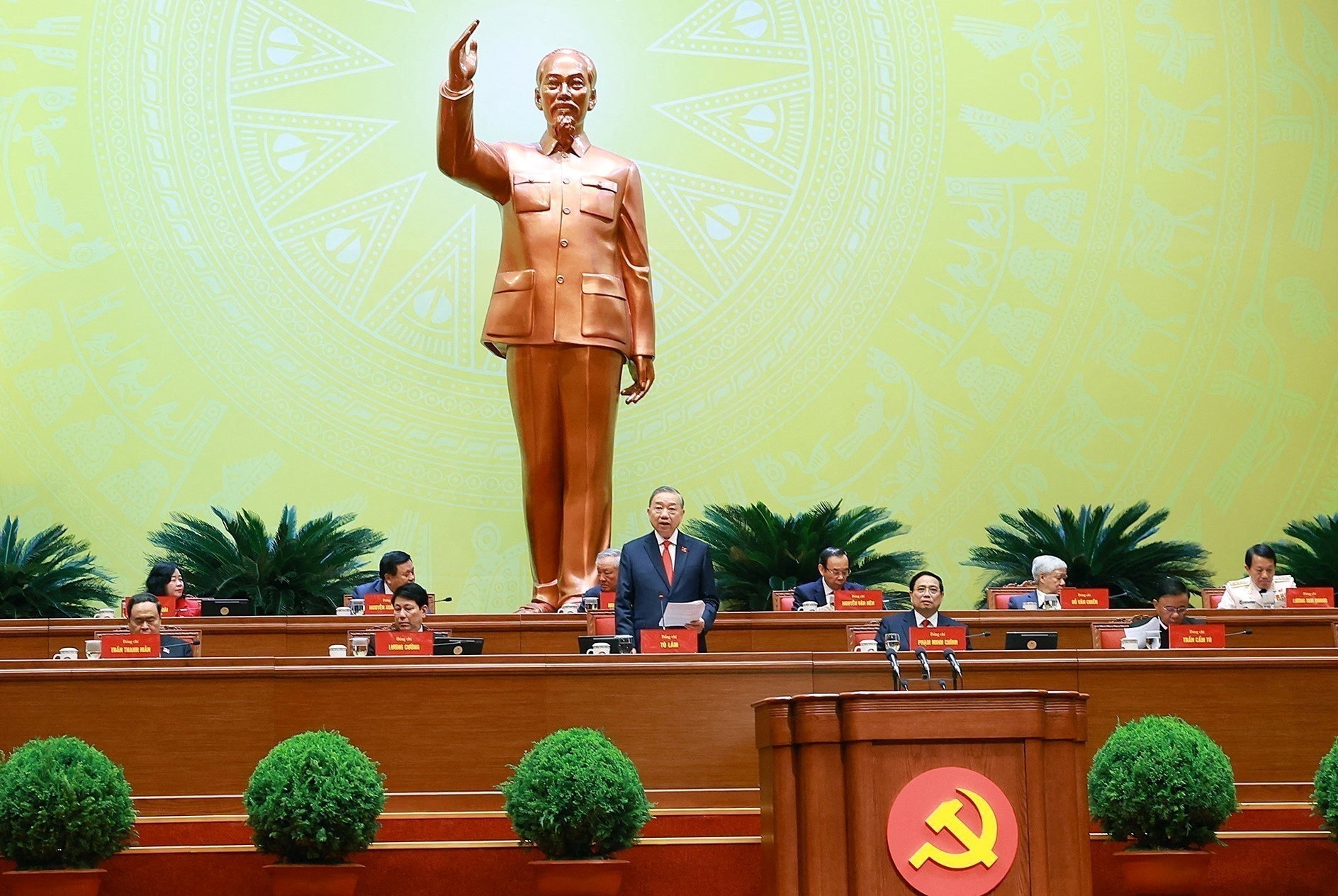 man in navy ⁢suit delivers ​address to ⁢general congress underneath bronze statue of man