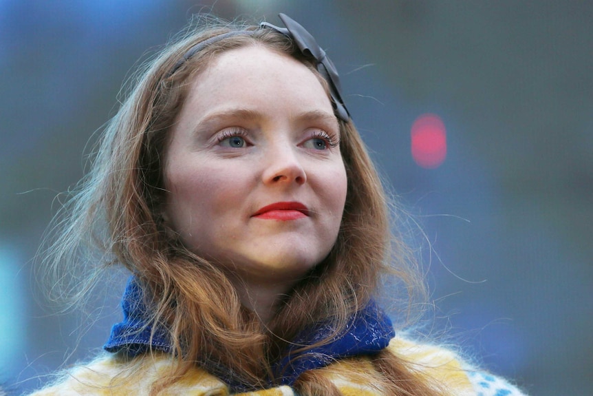 Lily Cole wears a black headband and colourful coat.