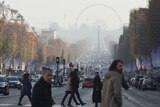 People cross the Champs Elysees avenue as Paris suffers smog