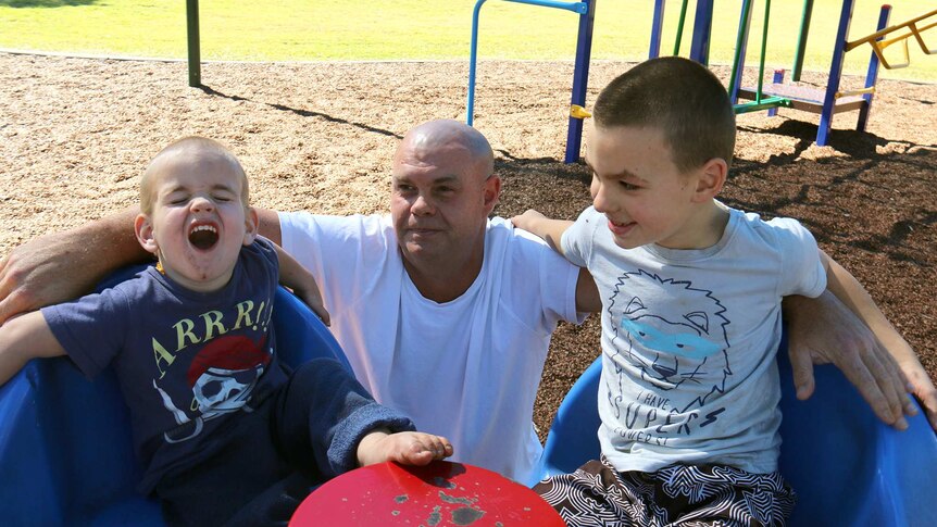 Brett Kelly at a playground with his two children Daniel, aged 7, and Liam, 3.