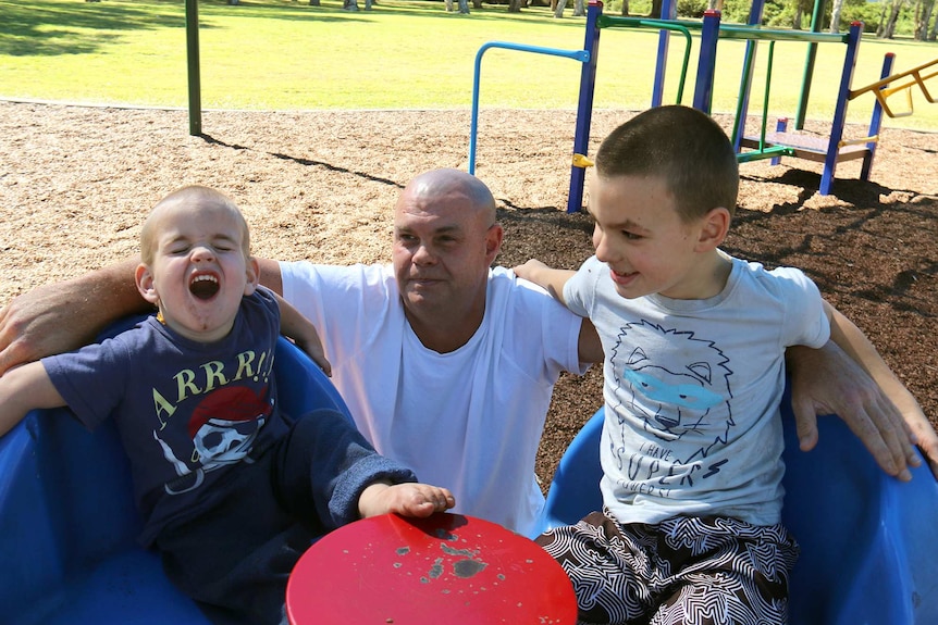 Brett Kelly at a playground with his two children Daniel, aged 7, and Liam, 3.