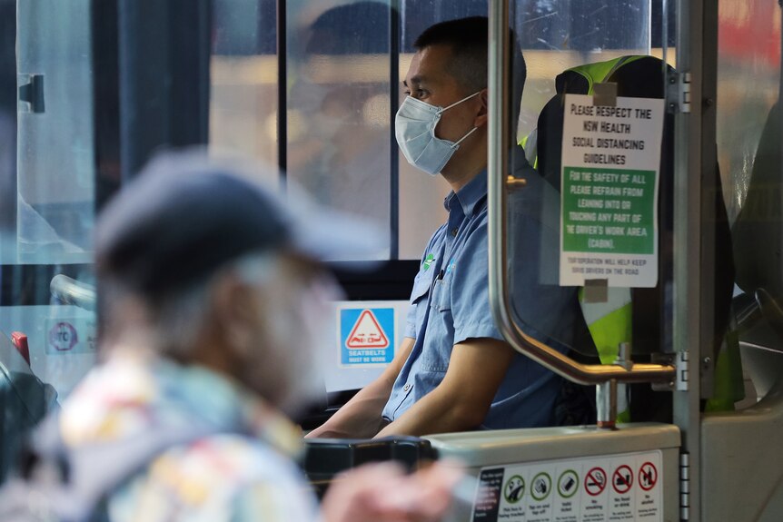 a bus driver wearing a mask