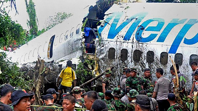 Indonesian soldiers and police examine the Merpati airline Boeing 737.