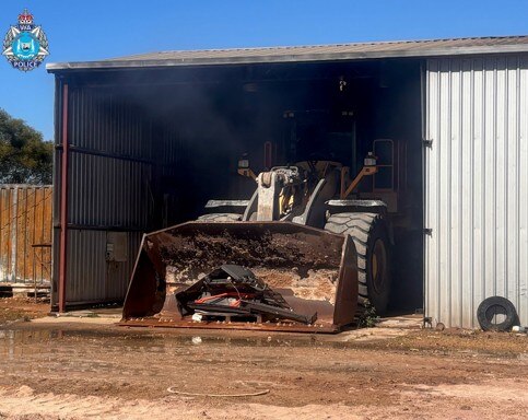A burnt out loader sits in a shed