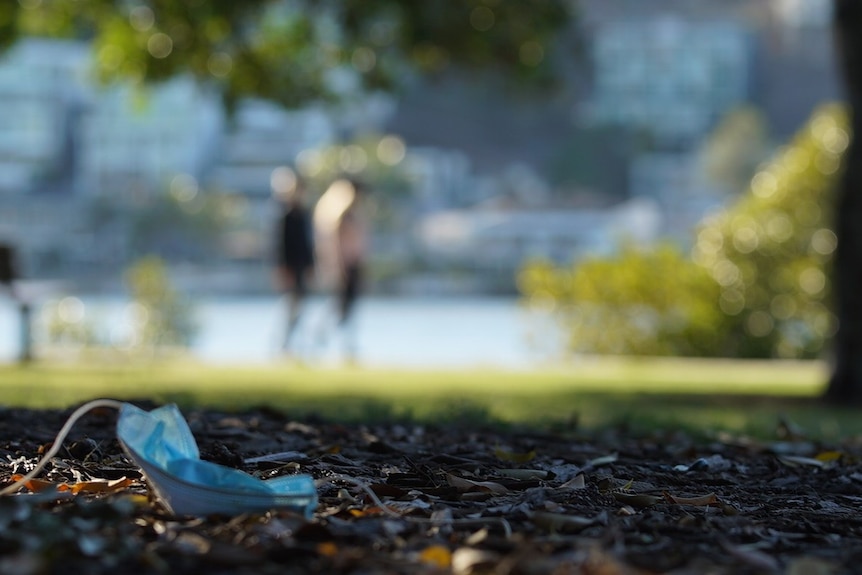 A discarded mask sits on the ground.