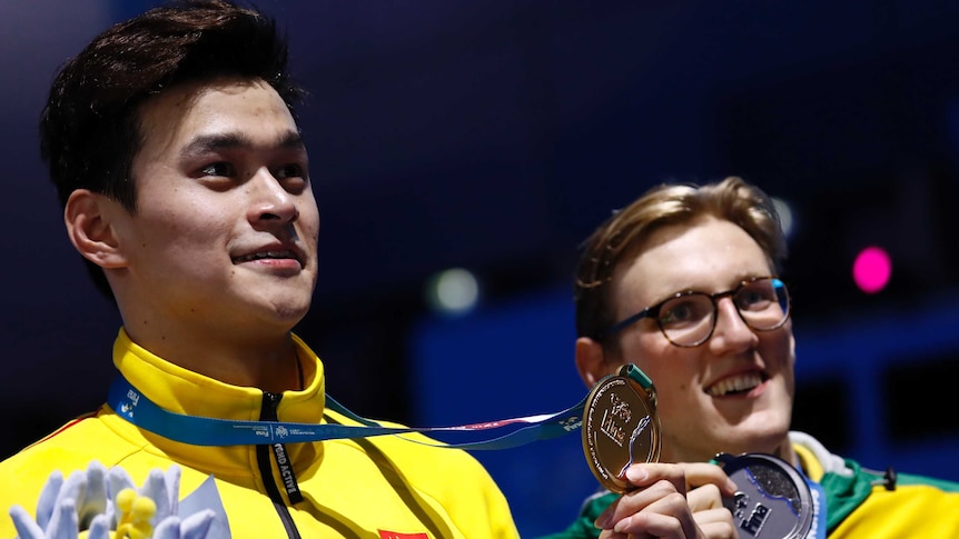 Sun Yang holds his gold medal and Mack Horton his silver