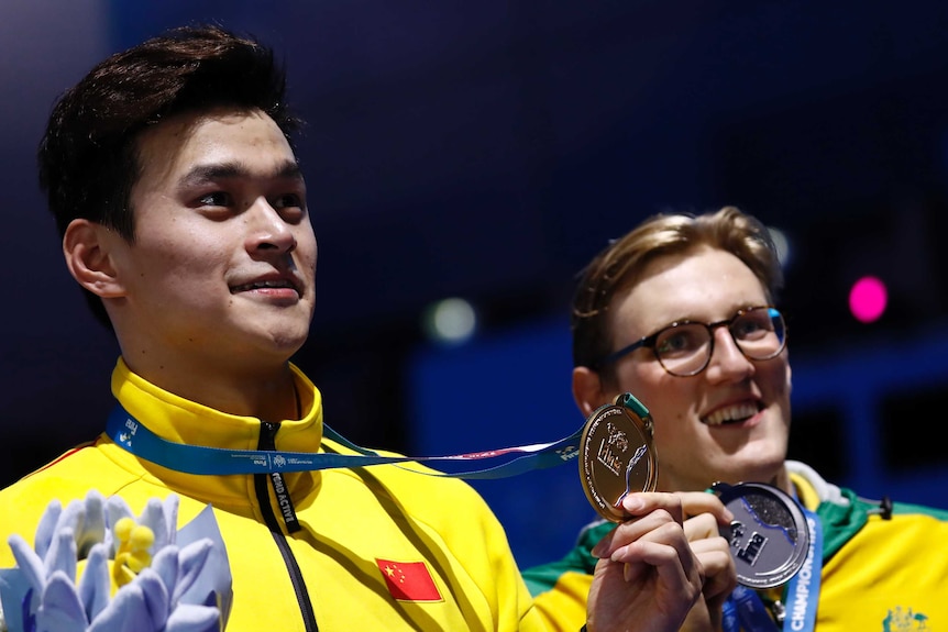 Sun Yang holds his gold medal and Mack Horton his silver