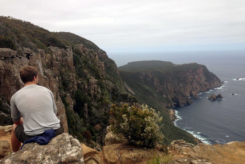 A bushwalker takes a break on the Cape Raoul Walking track in south-east Tasmania.