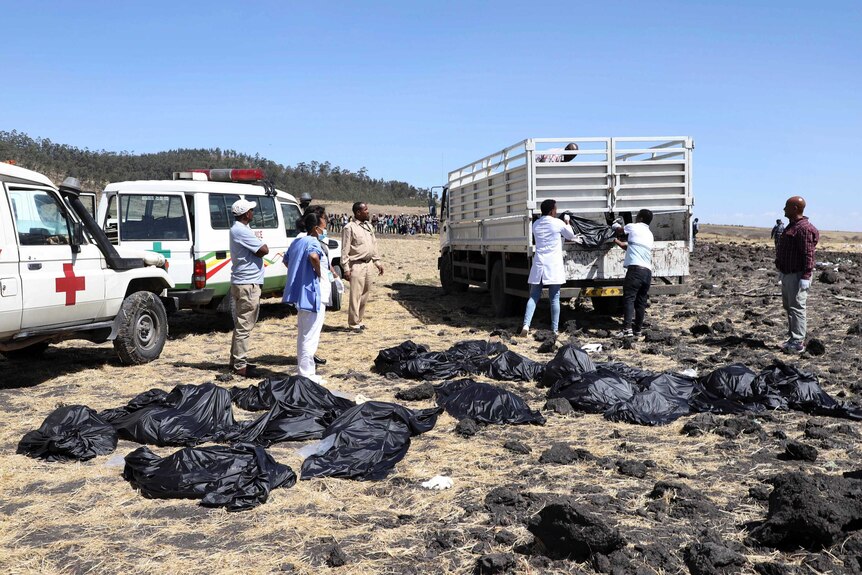 Rescuers remove body bags from the scene of an Ethiopian Airlines flight that crashed
