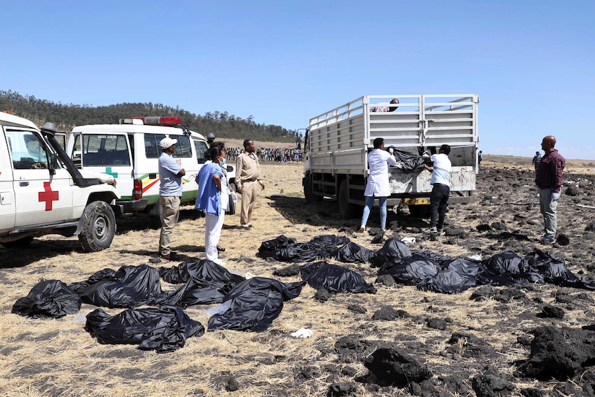 Rescuers remove body bags from the scene of an Ethiopian Airlines flight that crashed