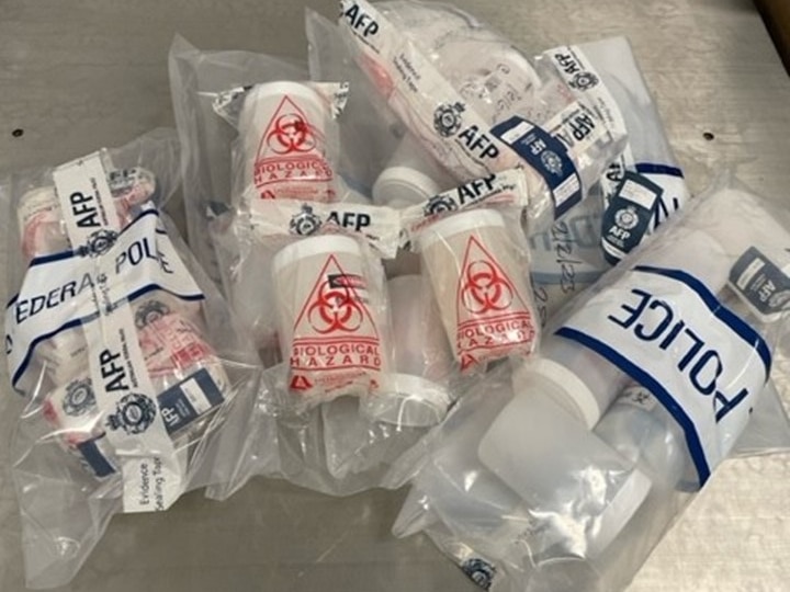 Evidence bags showing cocaine pellets inside hazmat containers.