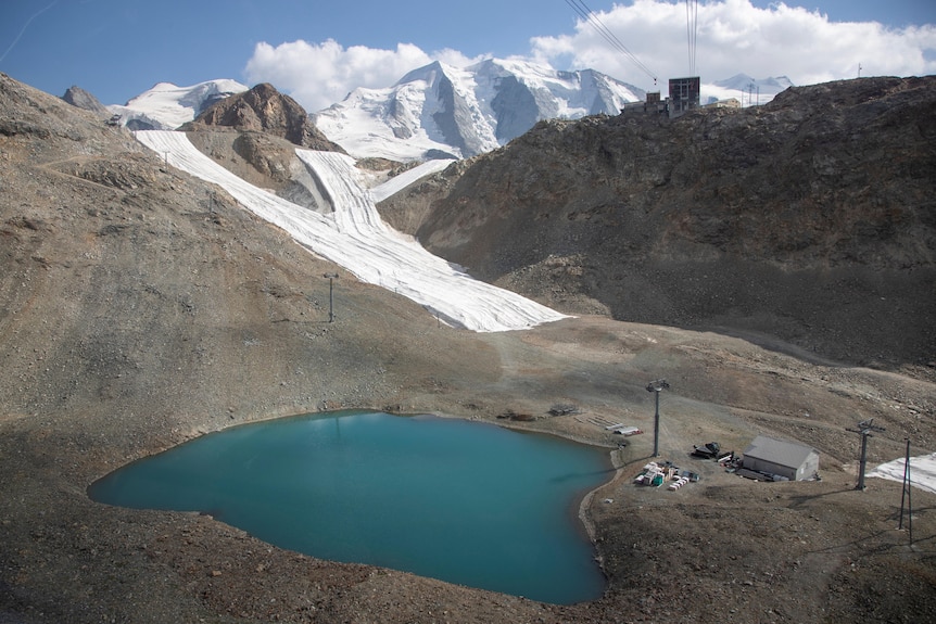 White blankets sit on sloping areas of land. 