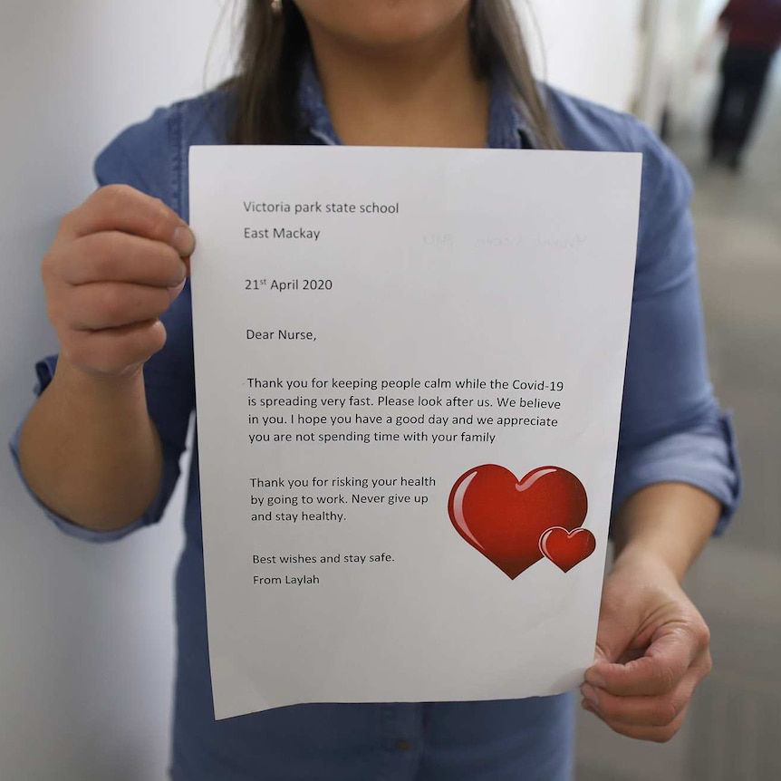 A worker holding a thank you letter from a young school student