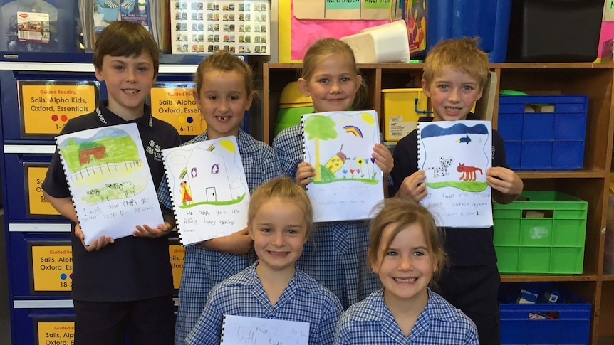 Unley Primary School students holding their drawings for the bushfire victims