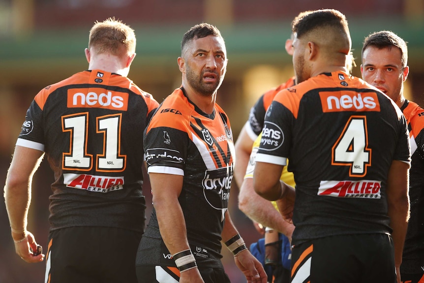 Benji Marshall looks upwards. He has teammates standing around him.