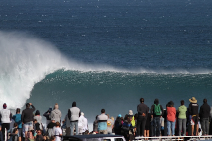 A big wave breaks in front of spectators in Margaret River