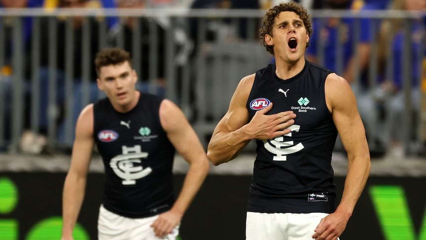 A Carlton AFL player puts his hand on his chest after he kicks a goal against West Coast.