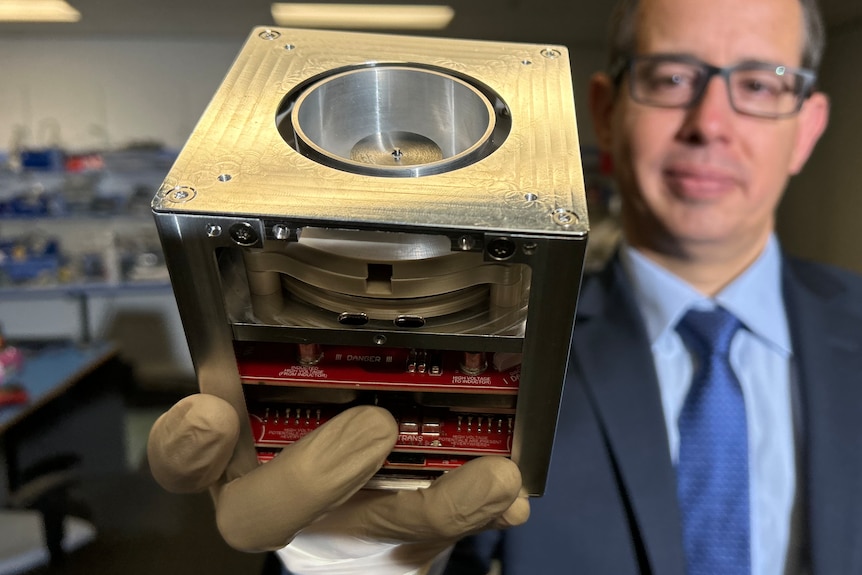 A man holding a high-tech space cube.