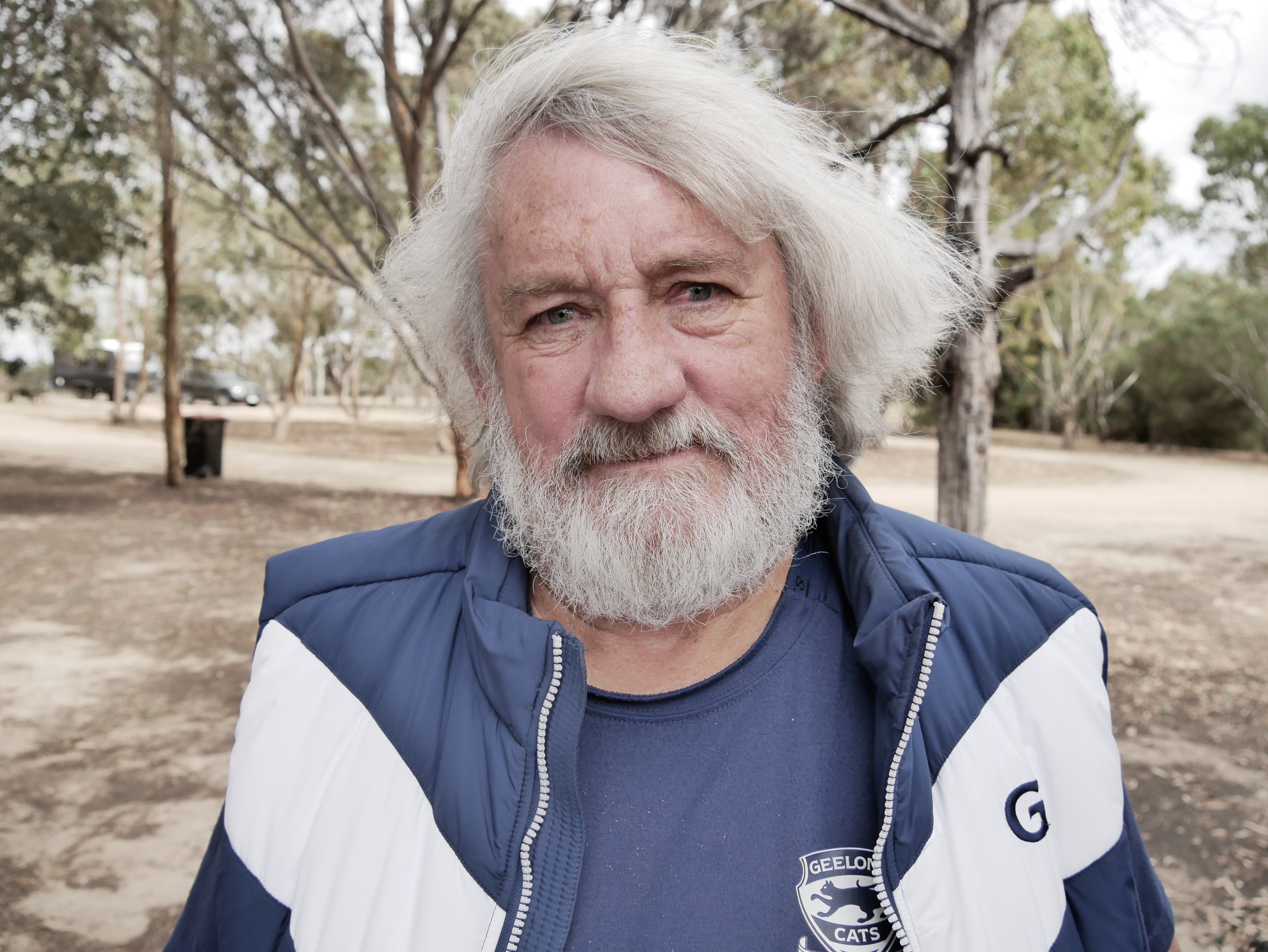 An older man with grey hair and a beard staring at the camera.