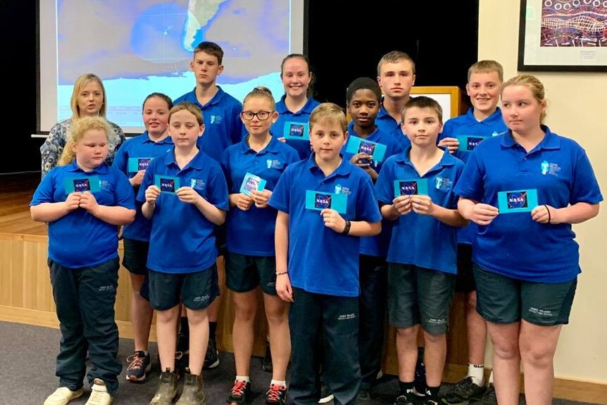 School students hold up NASA cards.