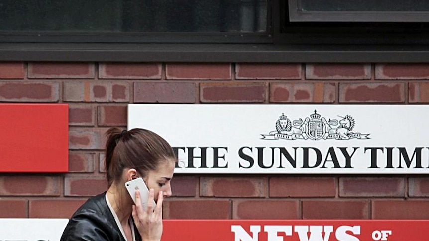 Woman walks past the News International HQ