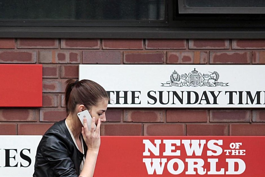 Woman walks past the News International HQ (Reuters: Olivia Harris)