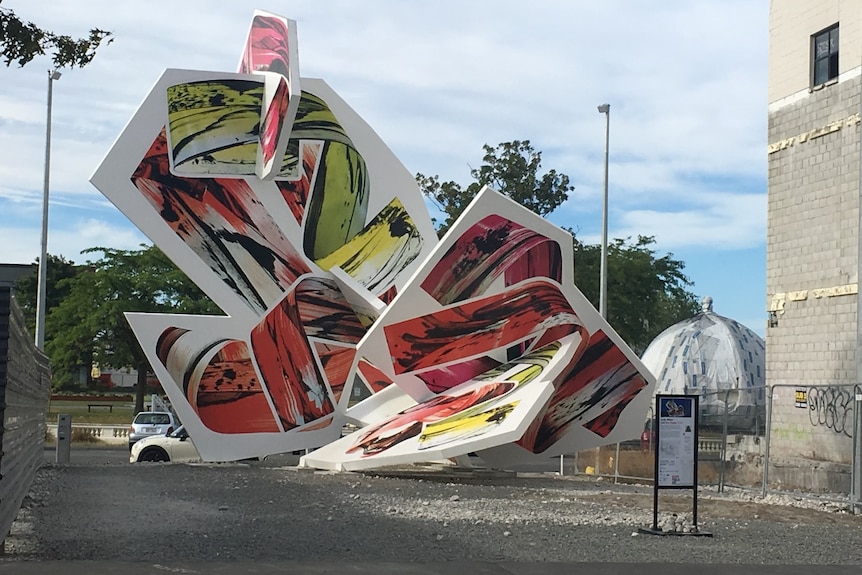 A large red and yellow abstract sculpture in Christchurch, New Zealand.