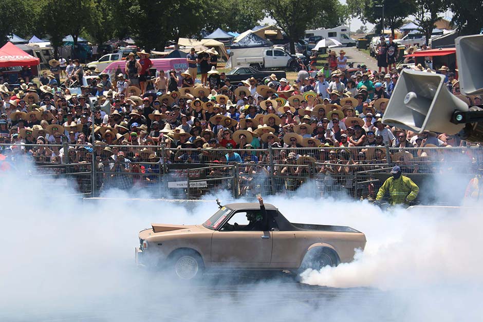 A car does a burnout in front of a packed crowd