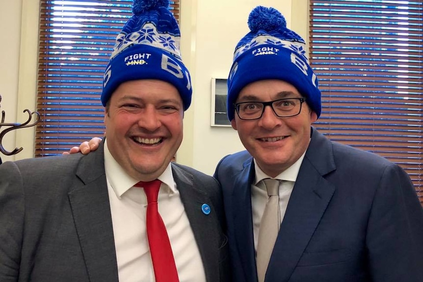 Will Fowles and Daniel Andrews wear beanies inside an office