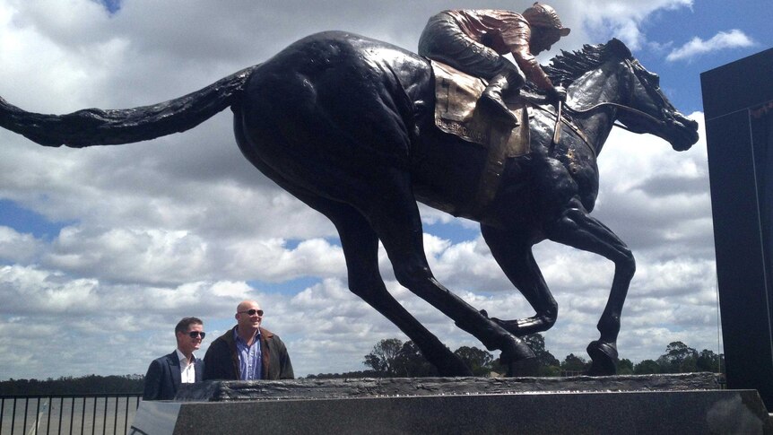 Luke Nolen and Peter Moody look at the statue of Black Caviar.