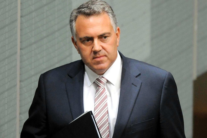 Joe Hockey walks through the House of Representatives.