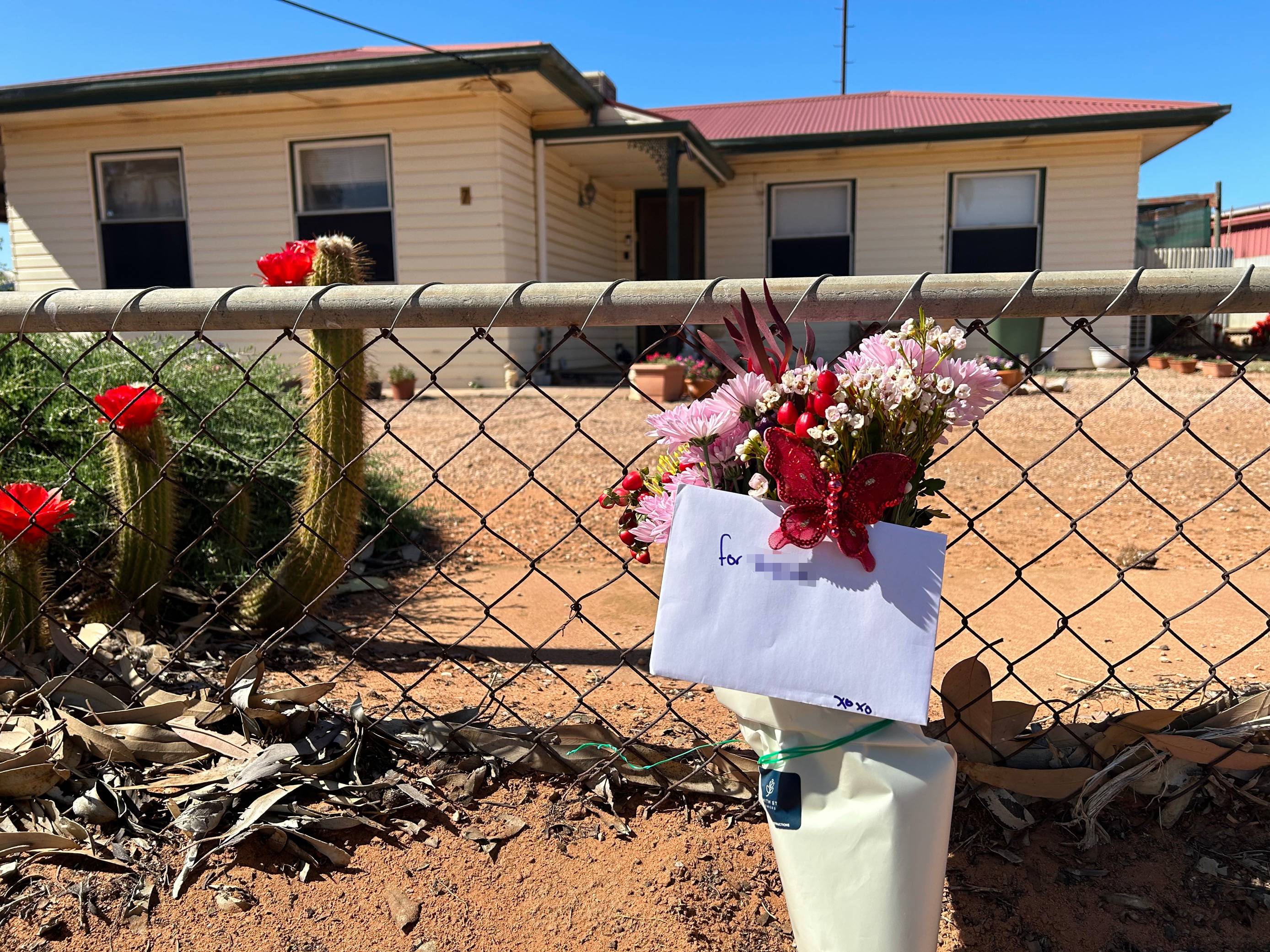 flowers and a card laid on a fence