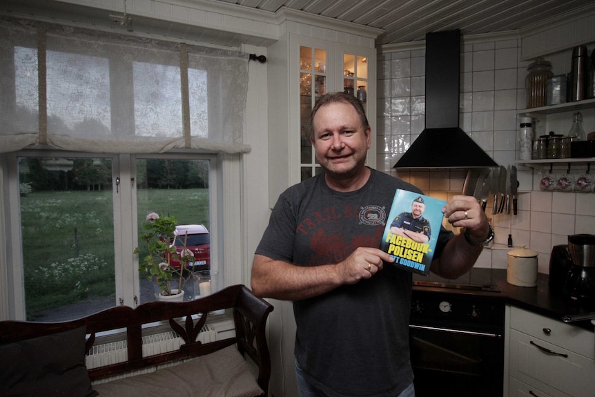 Scott Goodwin holds up his book