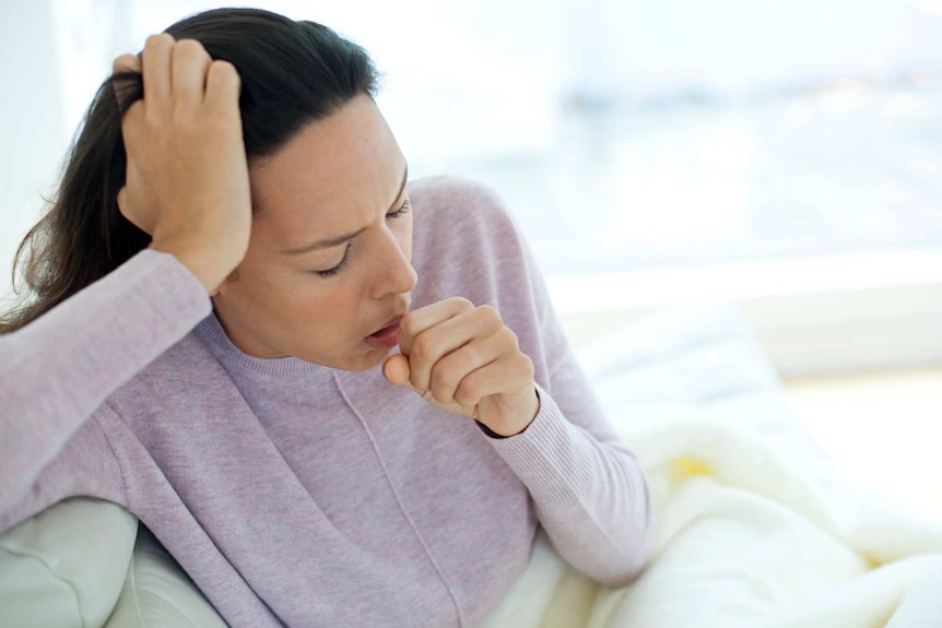 Young woman coughing.