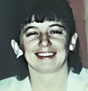 Close-up black and white photo of a woman smiling