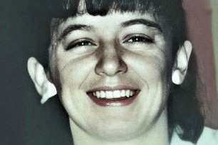 Close-up black and white photo of a woman smiling