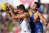 Rory Lobb comes under pressure from Tom Barrass as he tries to mark the football.