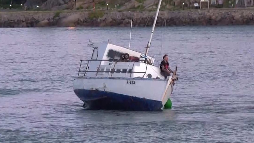 A boat skewing to its right with a man sitting on the side