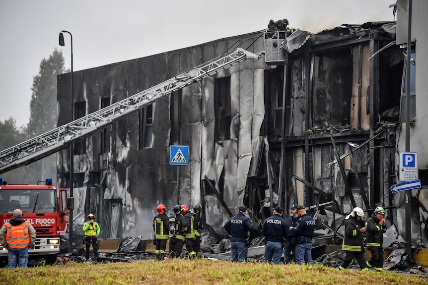 Firefighters work on the site of a plane crash, in San Donato Milanese