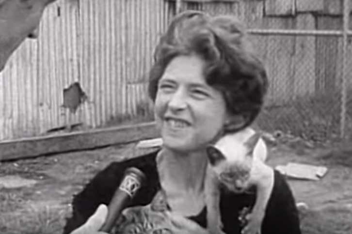 Still from 1969 black and white interview, with Mrs Morgan carrying a cat on her shoulder, talking to a reporter