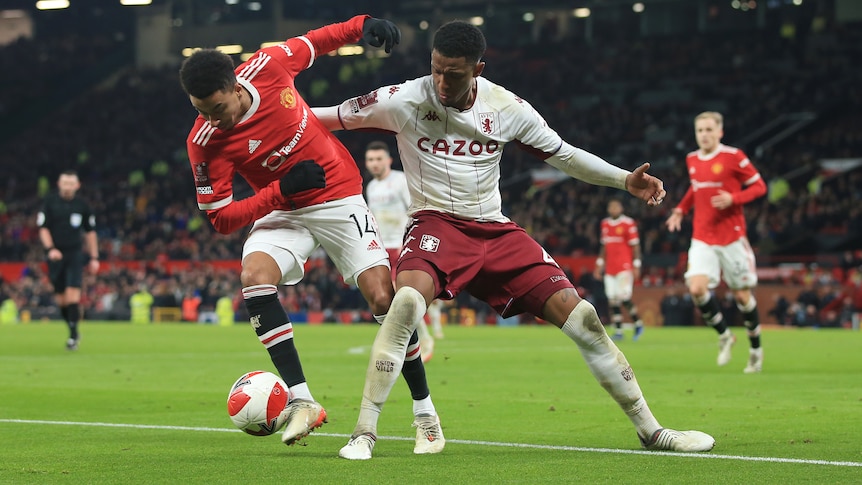 Premier League players from Manchester United and Aston Villa fight for the ball.
