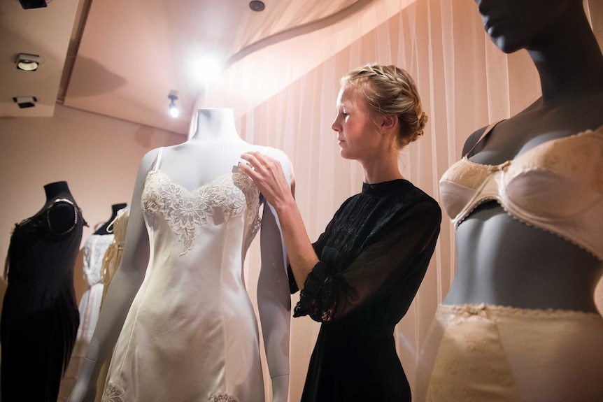 An assistant poses with a design included in the V&A Museum's underwear exhibition