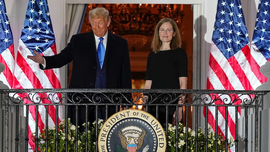President Donald Trump and Amy Coney Barrett stand on a Balcony