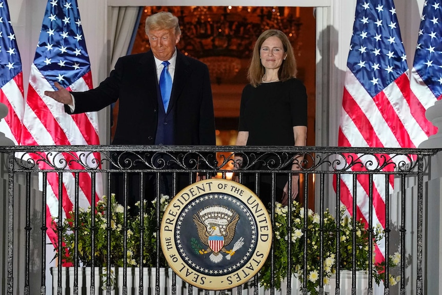 President Donald Trump and Amy Coney Barrett stand on a Balcony