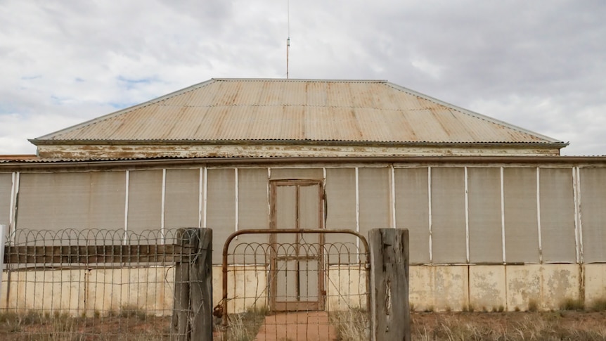 An old house with broken fence and gate sits abandoned on the main street of Ivanhoe.